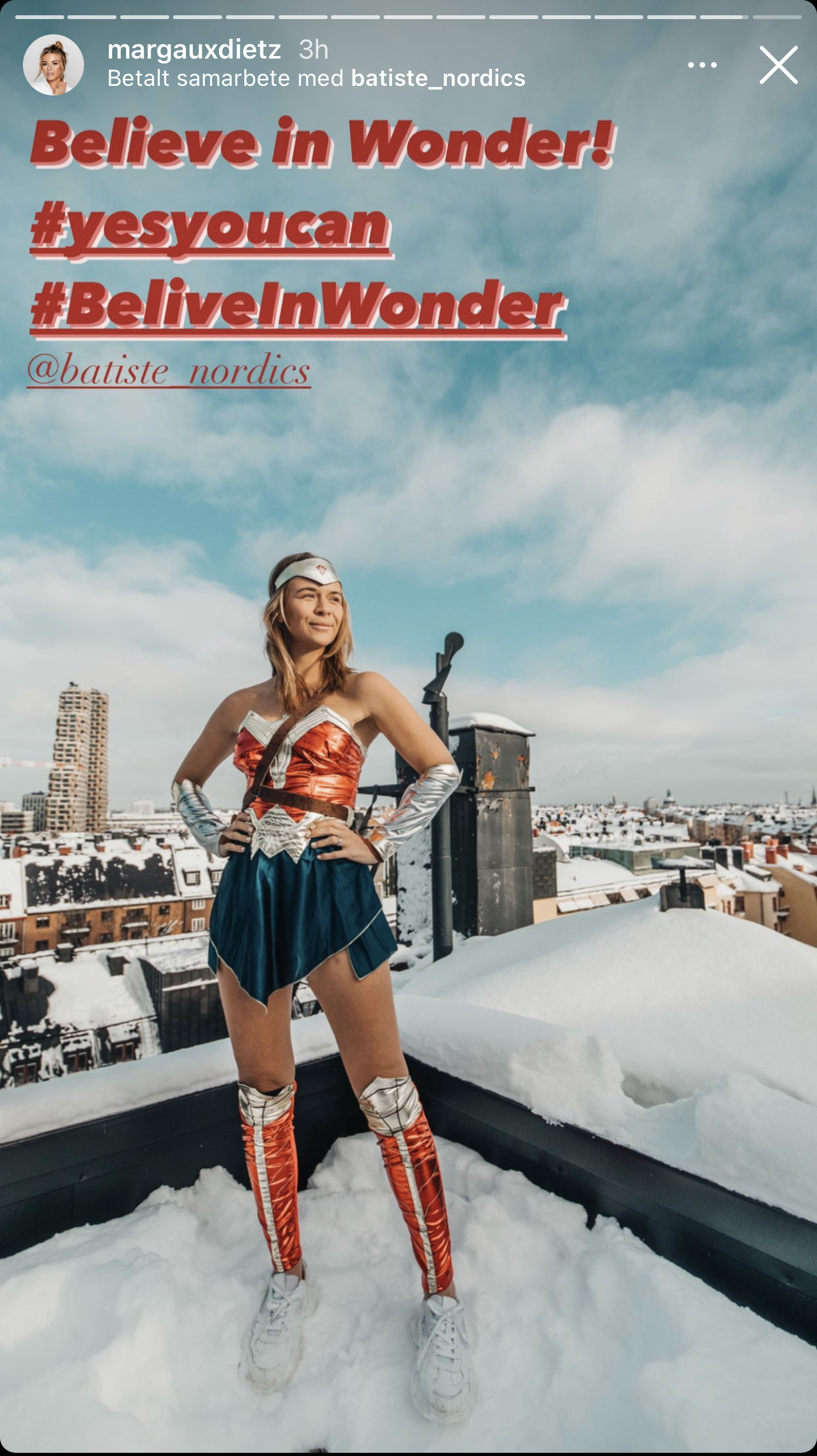 Margaux Dietz står iklädd en Wonder Woman-kostym uppe på ett snöigt tak