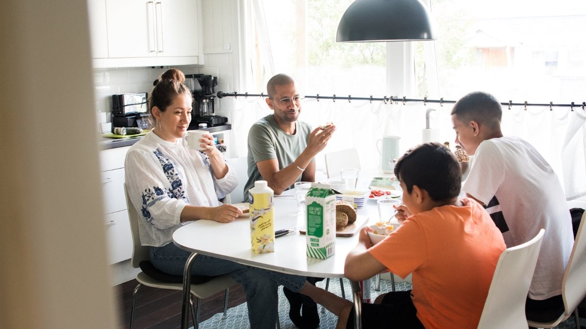 En familj sitter och äter vid middagsbordet.