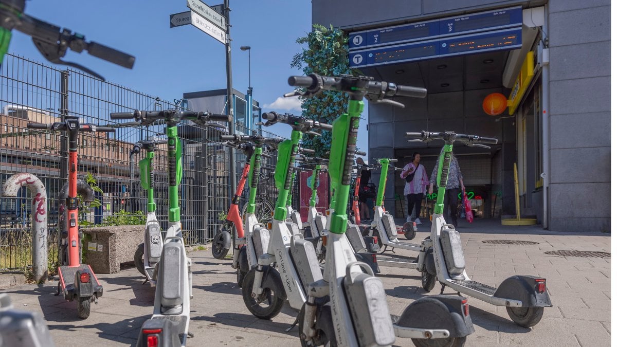 Lime och Voi-elsparkcyklar som står parkerade utanför en tunnelbaneingång.