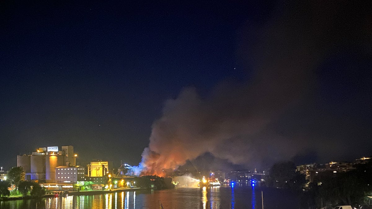 Brand i det gamla industriområdet i Lövholmen i södra Stockholm. Släckningsarbete pågår även från ett fartyg.