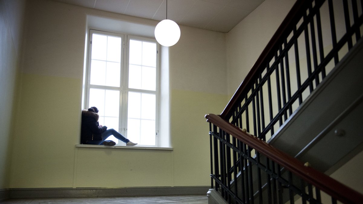 Ung tjej i skola sitter i fönster