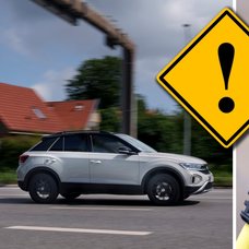 En elbil kör på en bilväg och en laddbox.