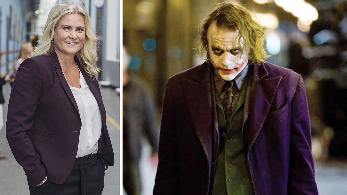 en blond kvinna i mörkblå kavaj, en man i clownsmink går