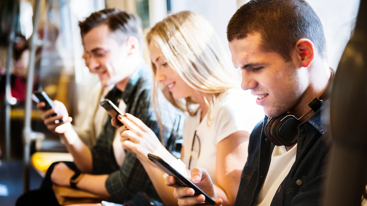 Personer i kollektivtrafiken som tittar i sina mobiler