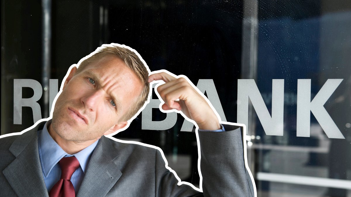 Riksbanken ingång med text Riksbanken på dörren. En funderande man som kliar sig i håret utklippt till vänster.