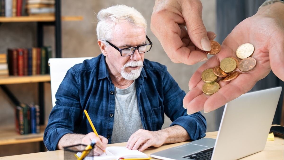 Äldre man som jobbar och en hand med mynt i.