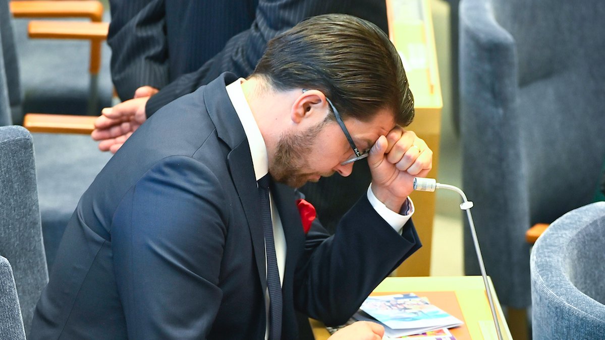 Jimmie Åkesson stirrar ner i sin mobil. 