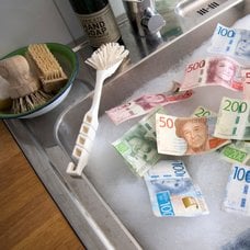 Kontanter som ligger i ett handfat och diskas