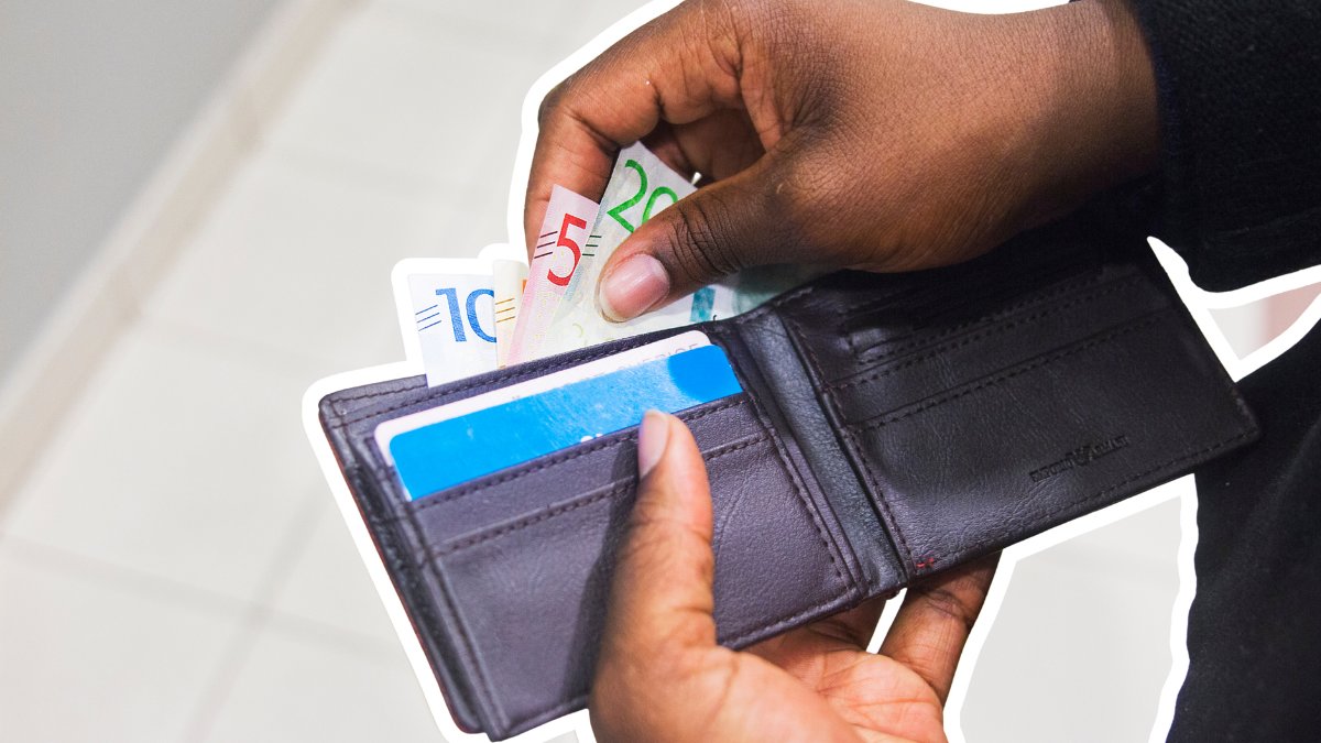 En person som har öppnat en plånbok med kontanter i och tar upp en kontantsedel.