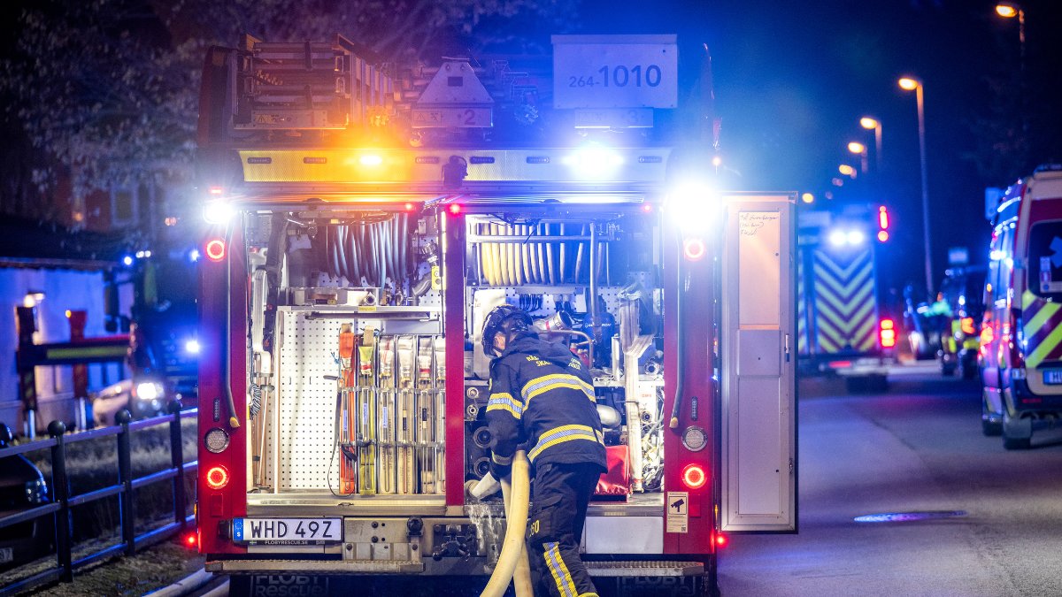 En brandman i baksidan av en brandbil.