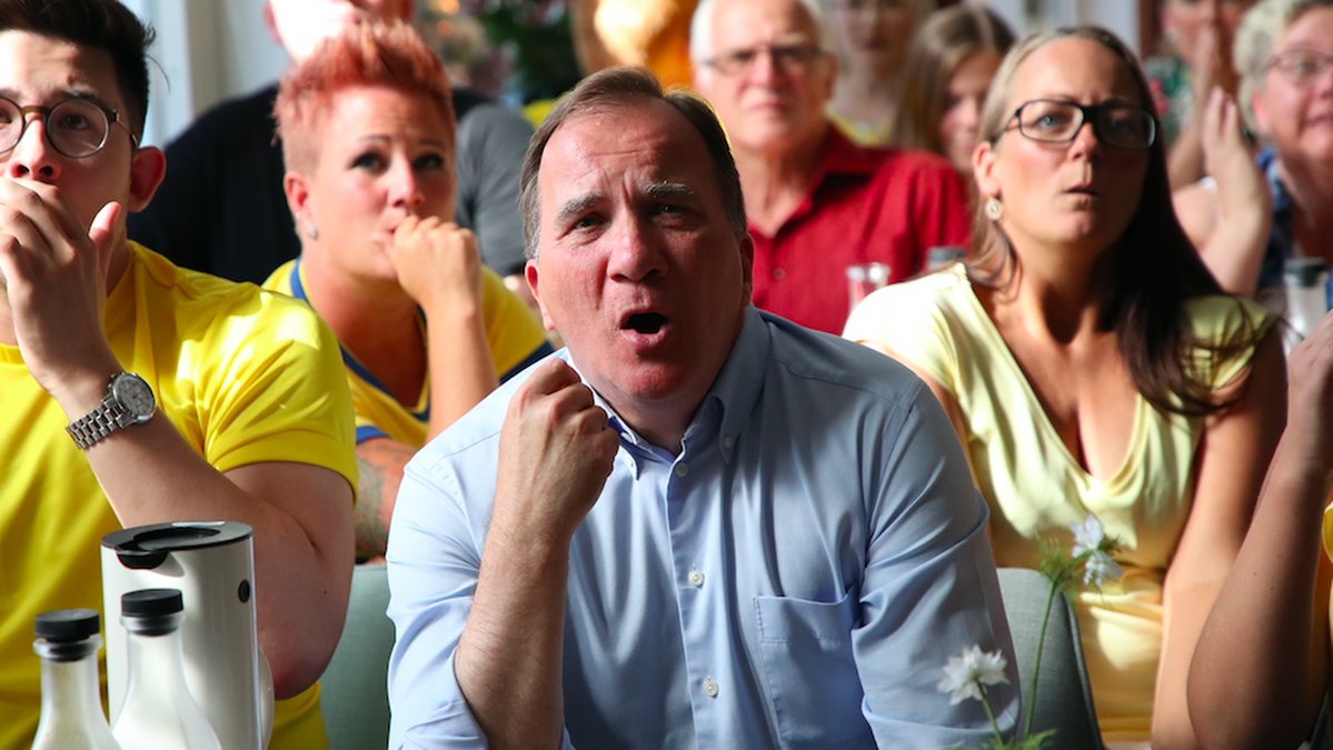 Stefan Löfven tittar på fotboll. 