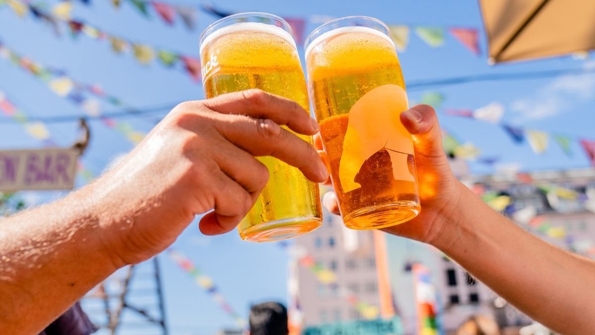 Bild på två som skålar i öl på en uteservering.