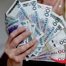 Svenska sedlar och en äldre dam som sitter med sin bankid.