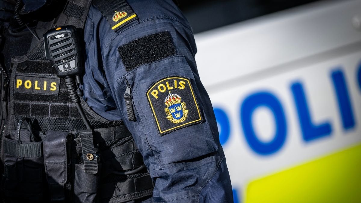 Polis framför en polisbil.
