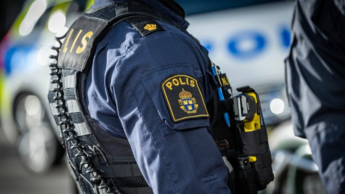Polis framför polisbil.