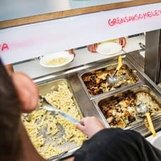 En skolmatsbuffé där barn tar sin mat.