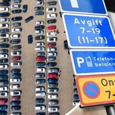 Parkering, parkeringsskyltar och en man i bil