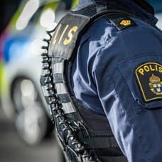 Polis framför polisbil.