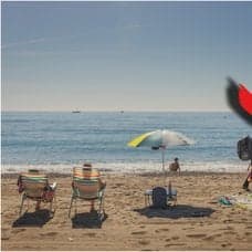 Genrebild från en strand i Spanien och ett betalkort.