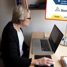 Kvinna vid en dator, appar och Skatteverkets hemsida.