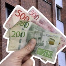 Person som håller i kontanter vänster. Skatteverket-skylt på en byggnad i bakgrunden.