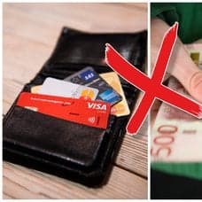 Plånbok med kort och en person med femhundralappar i händerna
