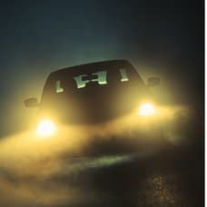 Bilbelysning och mörk bilväg.