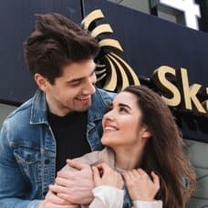 Par som tittar varandra i ögonen och Skatteverkets logga på fasad