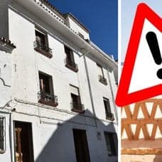 Spanskt hus vänster. en kvinna som solar på en balkong höger. Utklippt varningsskylt i mitten.