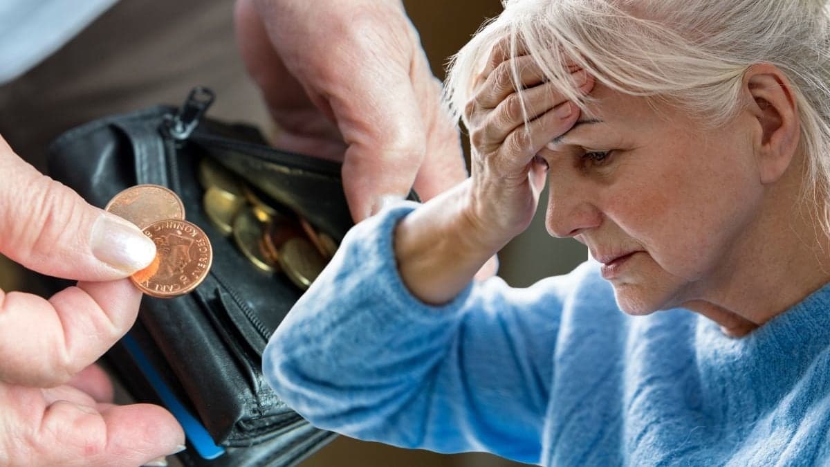 Plånbok med mynt och en kvinna med handen för pannan.