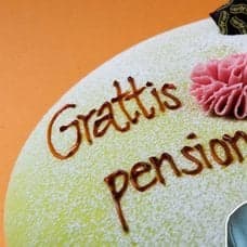 Tårta med texten Grattis till pensionen samt en äldre kvinna som är glad.