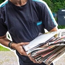 Postnord-anställd som delar ut brev och tidningar samt brevlådor