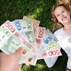 Pengar, en lycklig kvinna som ligger i gräset och en olycklig man som begraver ansiktet i händerna.