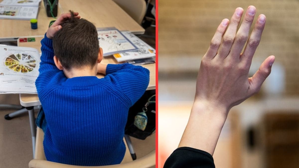 Pojke i skolbänk, elev som räcker upp handen.