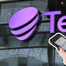 Telia-skylt i bakgrunden. Bild på händer som håller i en mobil till höger.