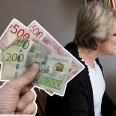 Pengar i handen och en kvinna vid en dator.