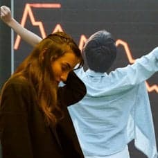 En röd graf i bakgrunden och framför syns en kvinna som ser ut att fundera, en person med utsträckta armar och en plånbok med sedlar i olika valörer.