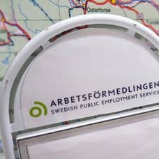 En karta i bakgrunden. En utklippt bild på En Arbetsförmedlings-skylt till vänster.