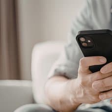 Person som håller i sin telefon.