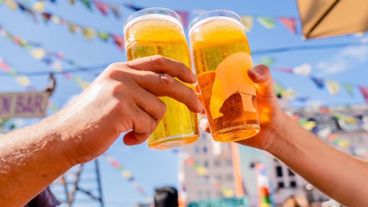 Bild på två som skålar i öl på en uteservering.