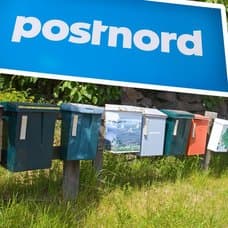 Postnord-skylt och brevlådor längs väg