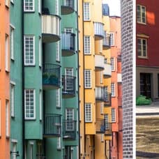 Bostadsrätter och bostadshus. Ett äldre par som går på en gata.