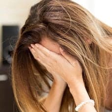 Ledsen kvinna och mynt i en hand.