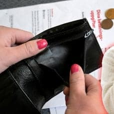 Elräkning, plånbok och en kvinna som har handen i pannan.