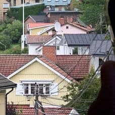 Hus i ett villaområde och en mobil med appar, exempelvis Skatteverket.