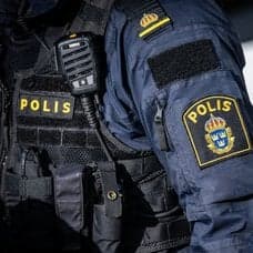 Polis framför en polisbil.