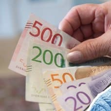 Pengar i en plånbok och en kvinna.