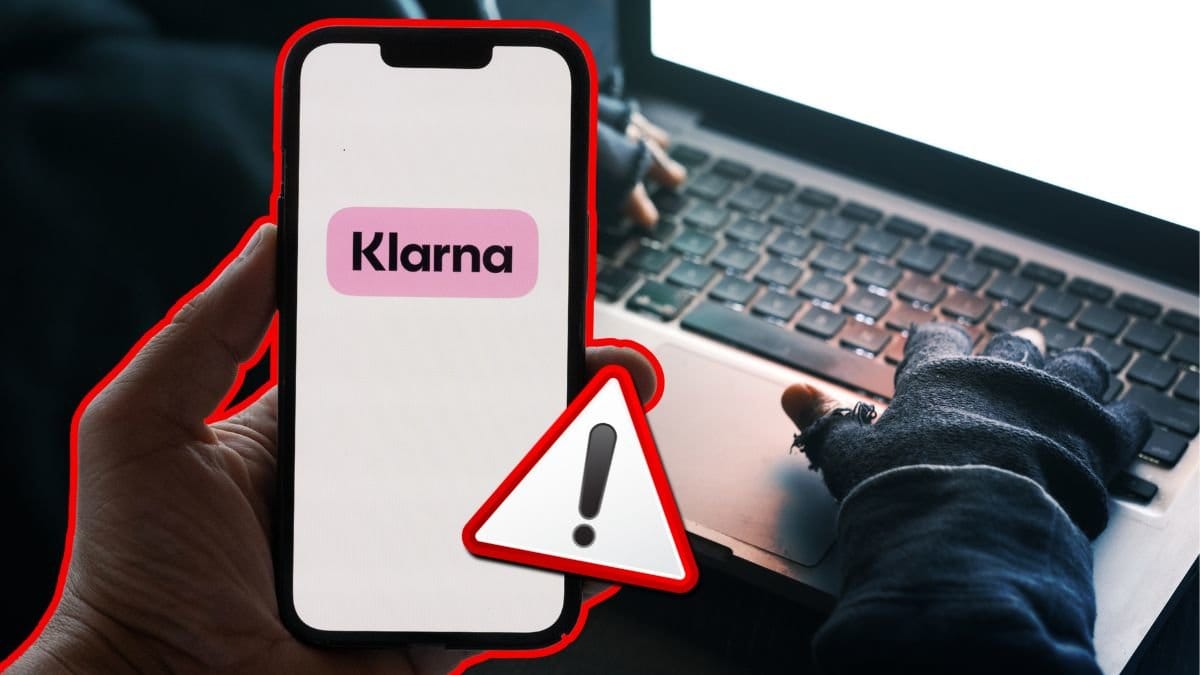 En hackare sitter framför en upplyst skärm och en mobil med en Klarna-logga.