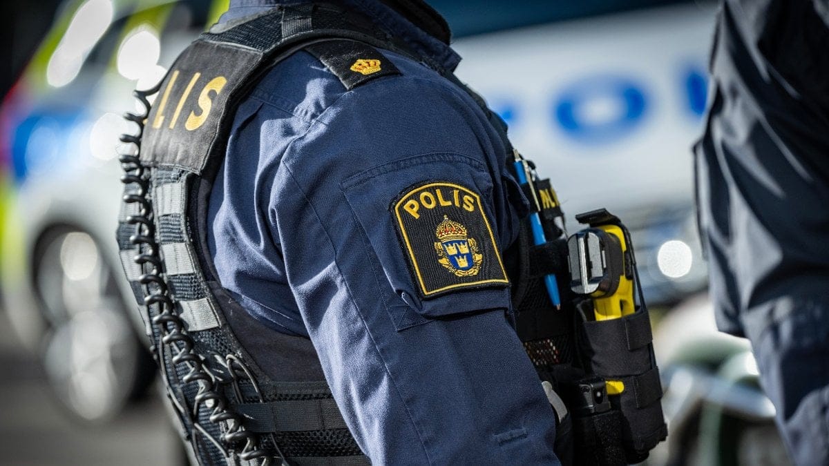 Polis framför en polisbil.