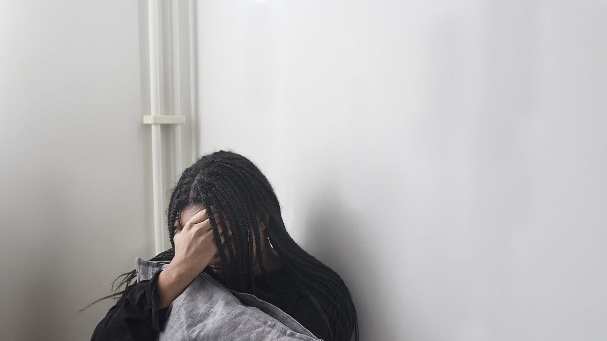 Ledsen kvinna som sitter på golvet